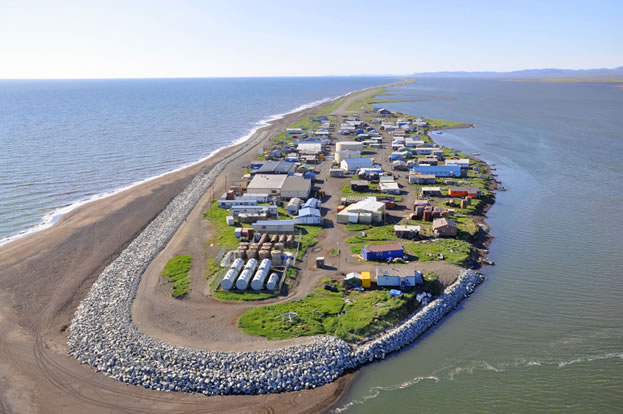 photo of a village on a sand-spit in the sea, riprap seawalls at one end